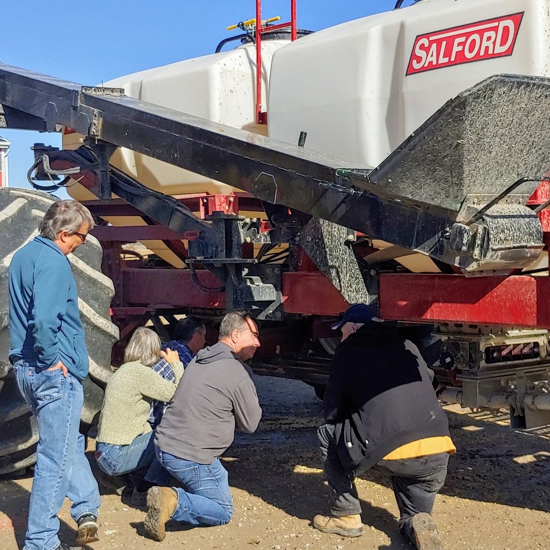 Henry Denotter and members of the Soil Resources Group checking out the variable rate fertilizer cart used throughout the fields that Henry farms