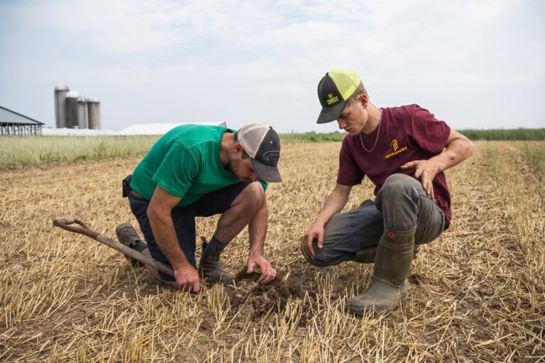 Gordon Alblas and his farm hand examine the health of their soil during a field walk.