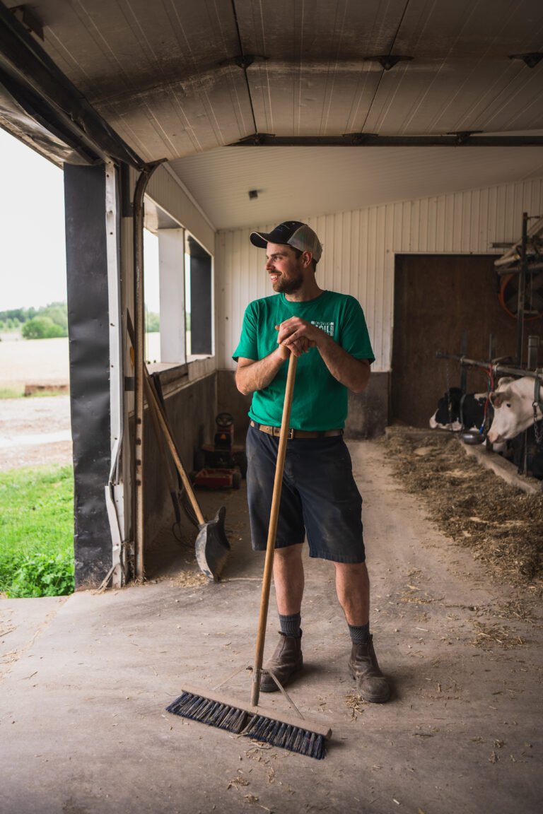 gordon alblas, OSN farmer, stand just inside the door of his dairy barn after sweeping the floor. Photographed by Ian Virtue